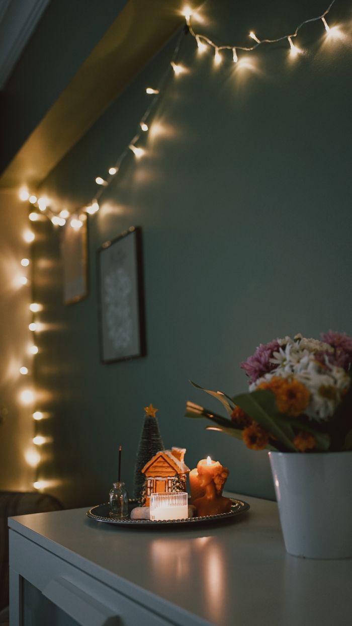 Warm and cozy indoor Christmas decor with fairy lights and gingerbread house.